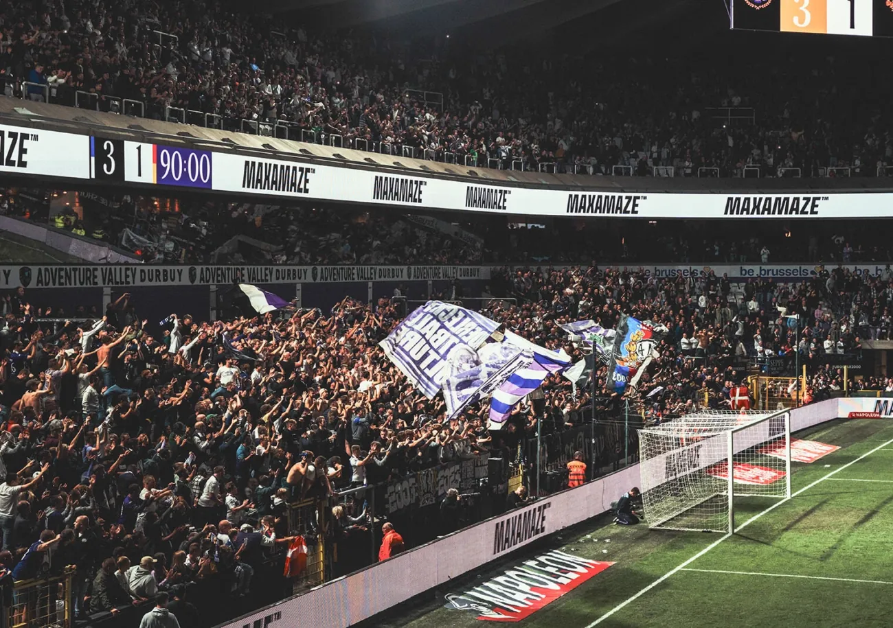 Lotto Park on a matchday: a packed stand behind the lit LED perimeter